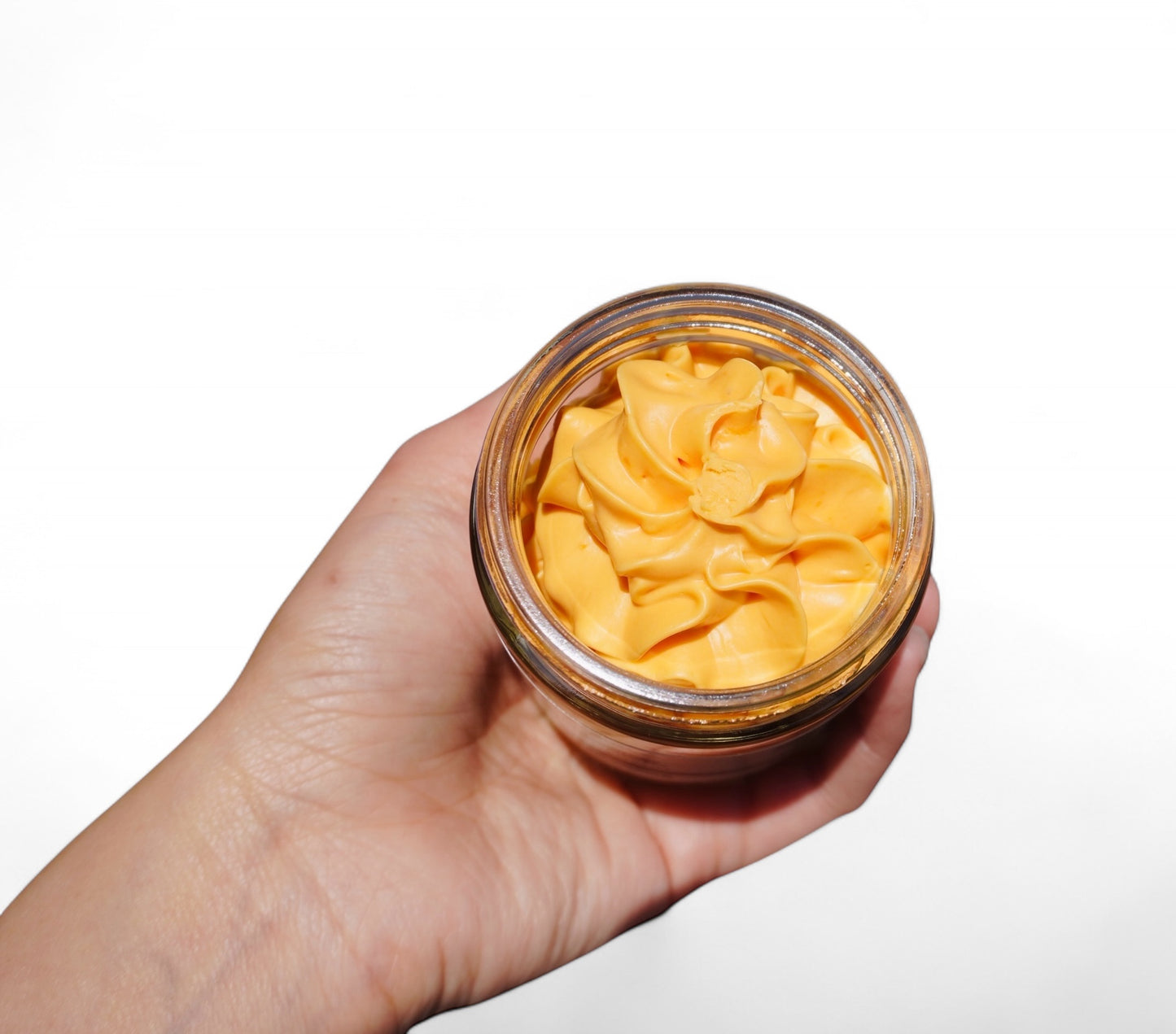 Cayenne pepper body butter jar held in hand showing 4 oz size and packaging of natural moisturizer