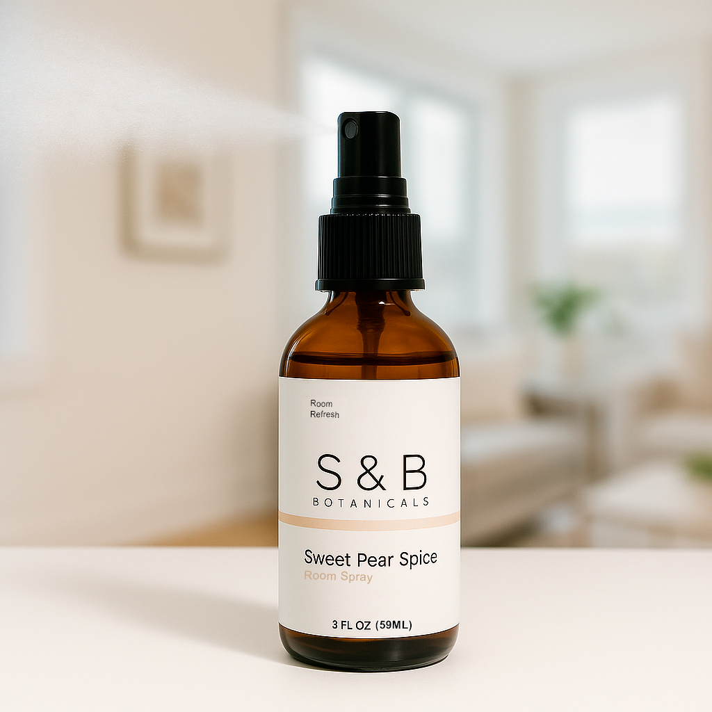 S&B Botanicals Room Spray amber glass bottle displayed on white surface in bright minimalist living room, 2oz water-based phthalate-free fragrance spray for any space