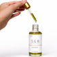 Close-up of dropper dispensing blue tansy face serum showing lightweight facial oil texture
