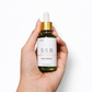 Hand holding blue tansy face serum bottle for size reference