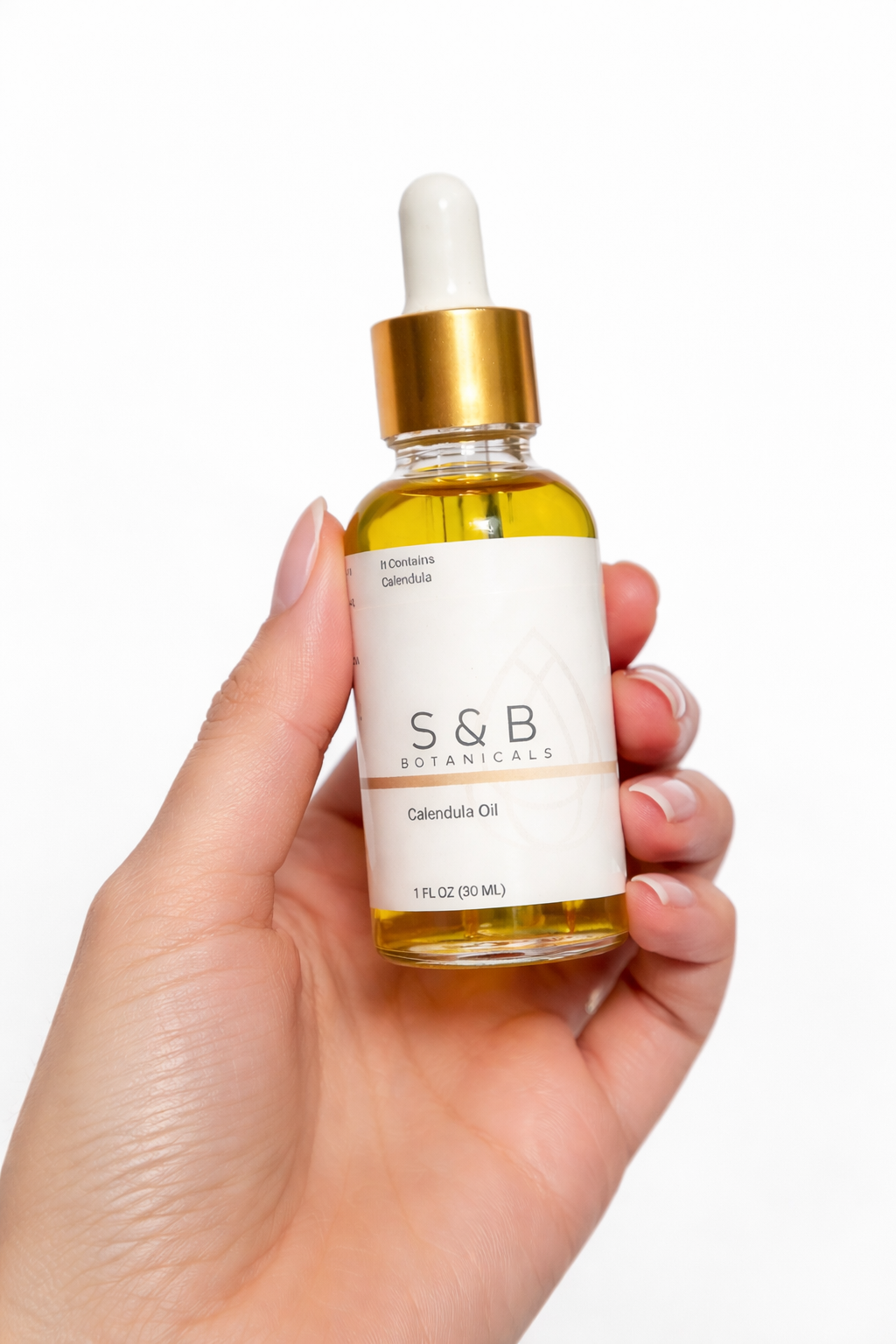 Calendula face and body oil held in hand for size reference