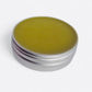 Close-up of comfrey salve texture showing smooth herbal balm consistency in metal tin