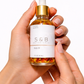 Hand holding lavender body oil dropper bottle natural botanical skincare oil for soft glowing skin