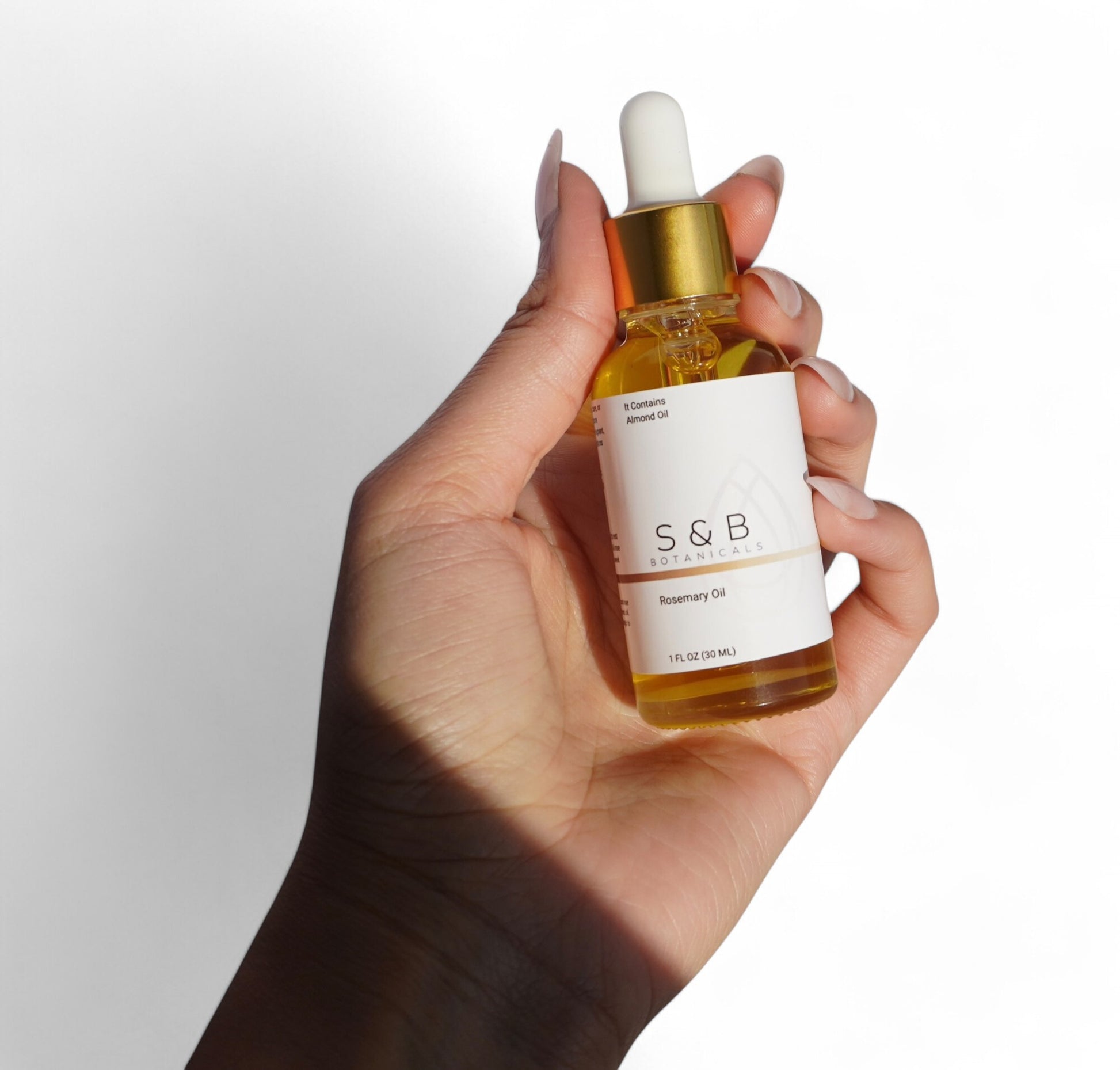 Close up of rosemary peppermint hair oil label herbal infused botanical scalp oil glass bottle